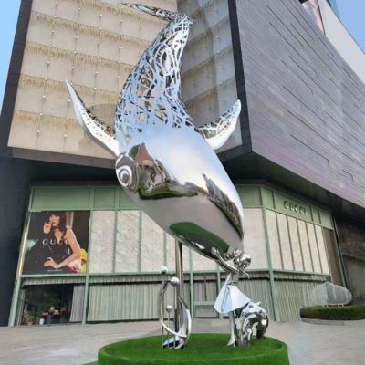 Escultura de baleia em aço inoxidável iluminada à noite na cidade com luz